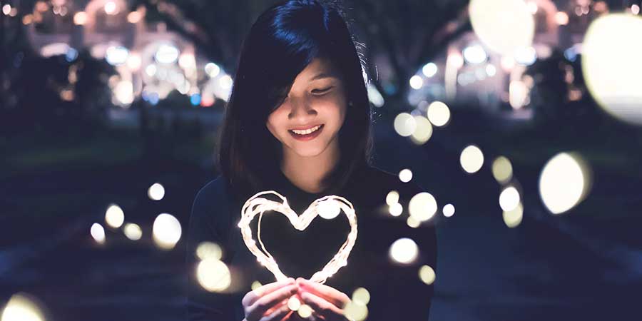 Woman holding lights in the shape of a heart