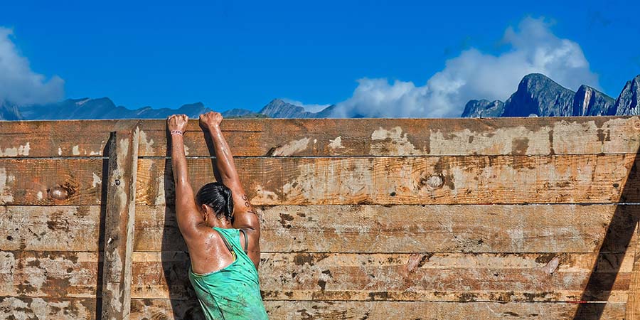 Woman climbing over Wall